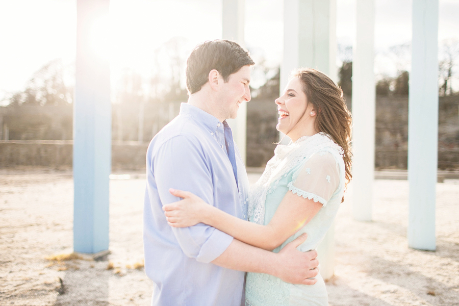 Spring Engagement shoot at Dysart Harbour in Fife - couple embrace at sea beams statue